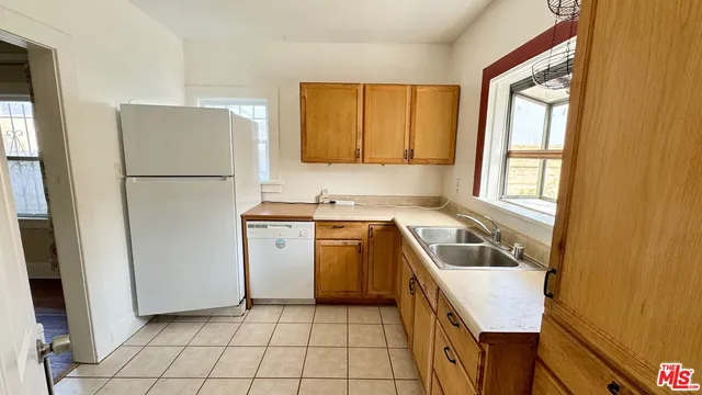 a kitchen with a refrigerator sink and cabinets