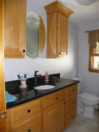 10 Blueberry Road, Unit R Derry, NH 03038 - Photo 13 of 15 a bathroom with a granite countertop sink a mirror and a toilet