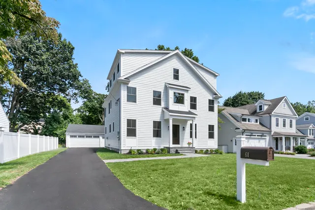 a view of a white house with a big yard and large trees