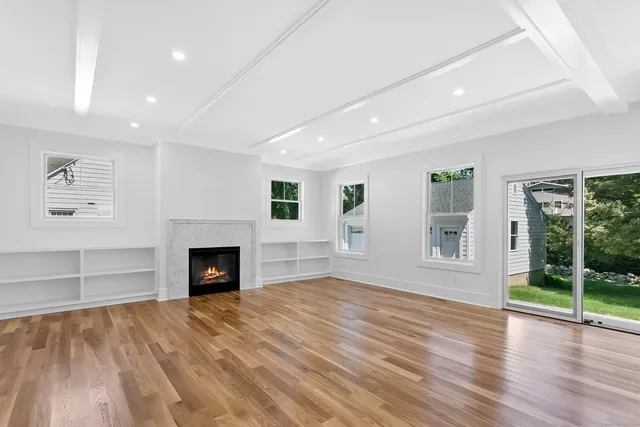 a view of an empty room with window and fire place