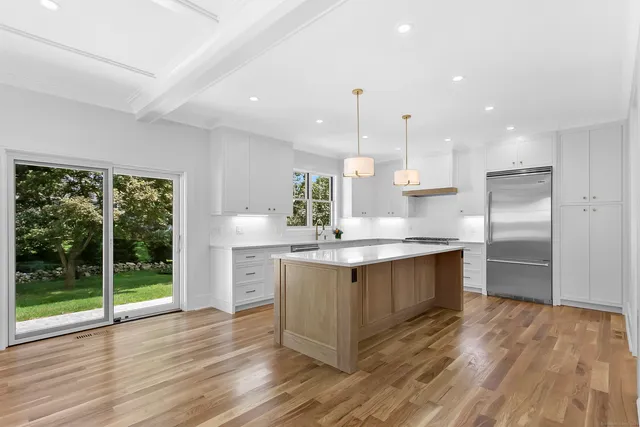 a kitchen with stainless steel appliances granite countertop a sink a stove and a wooden floors