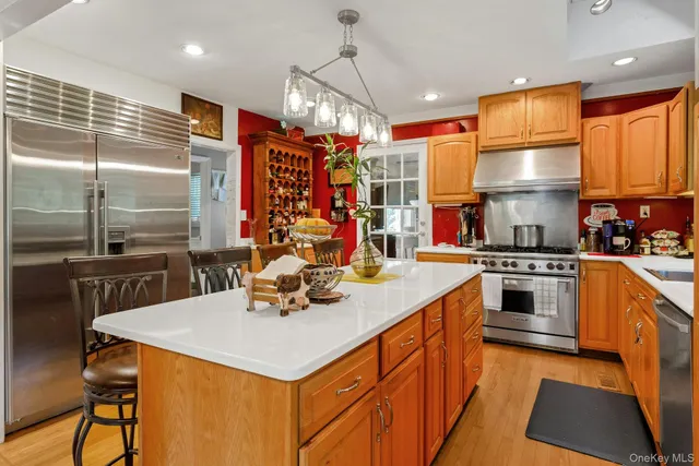 a kitchen with stainless steel appliances granite countertop a sink a stove and a refrigerator