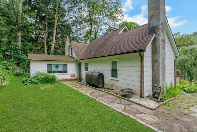 a view of house with backyard and outdoor seating