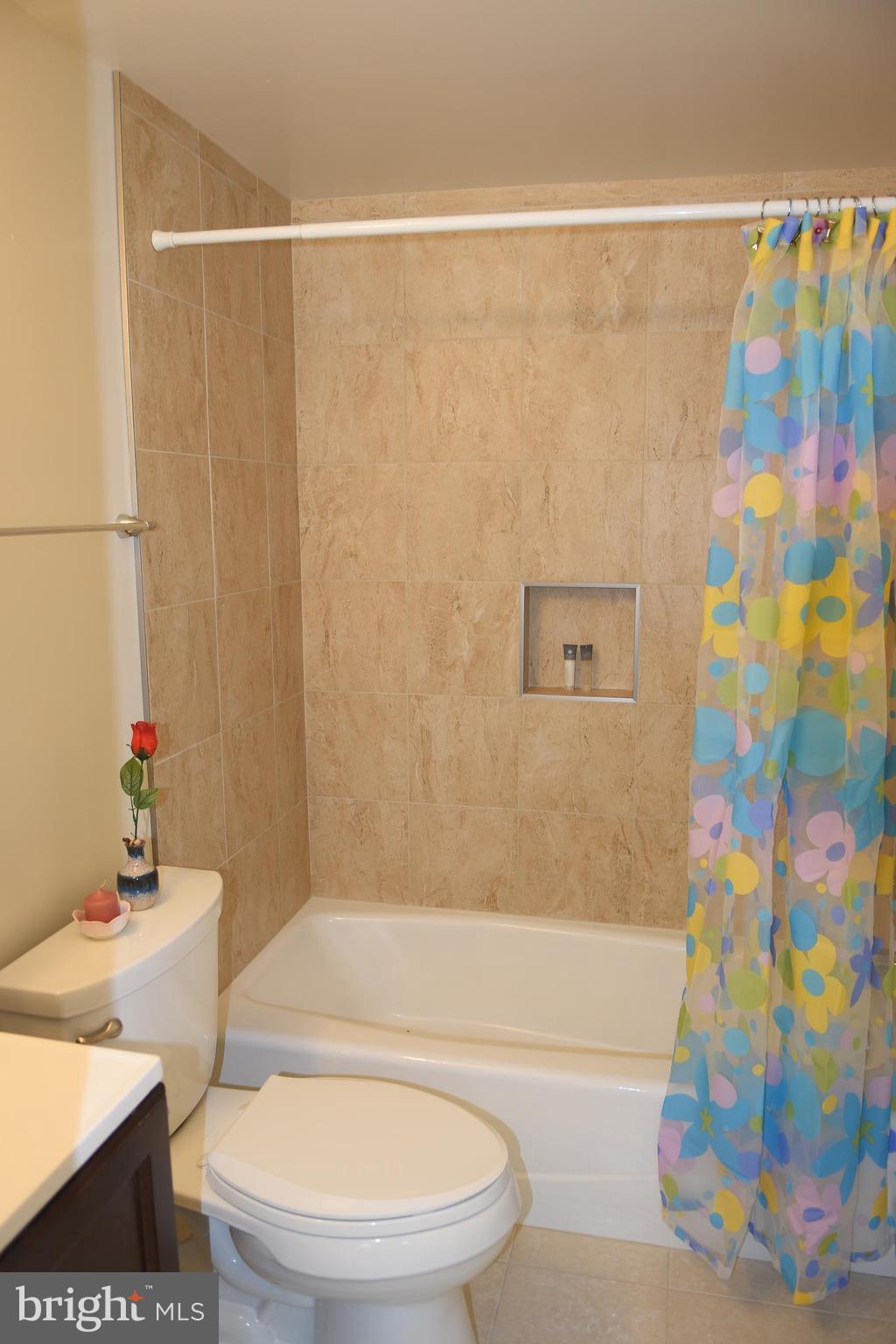 8127 Carrick Lane Springfield, VA 22151 - Photo 12 of 15 a bathroom with a toilet and a shower curtain
