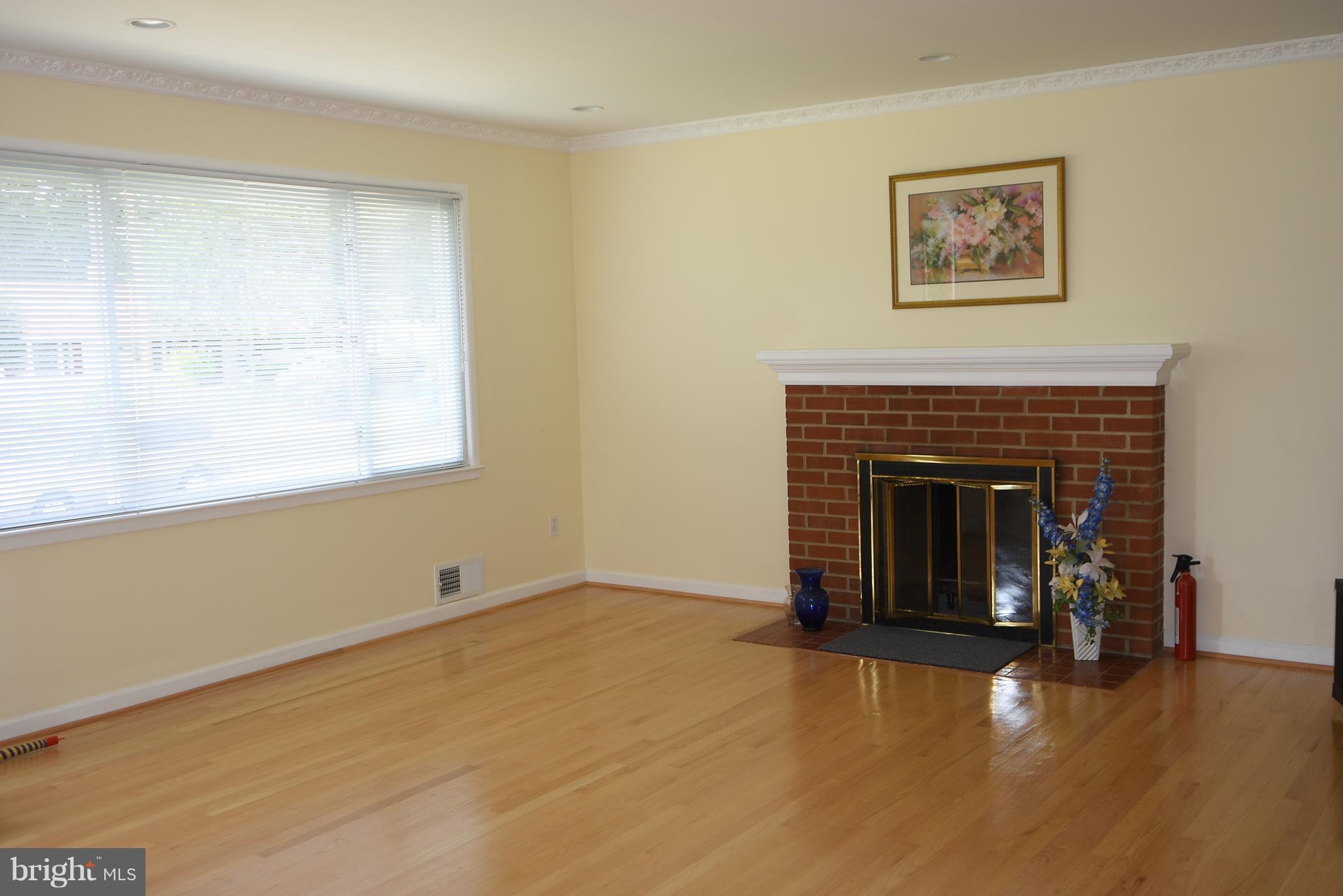 8127 Carrick Lane Springfield, VA 22151 - Photo 4 of 15 a view of an empty room with a fireplace and a window
