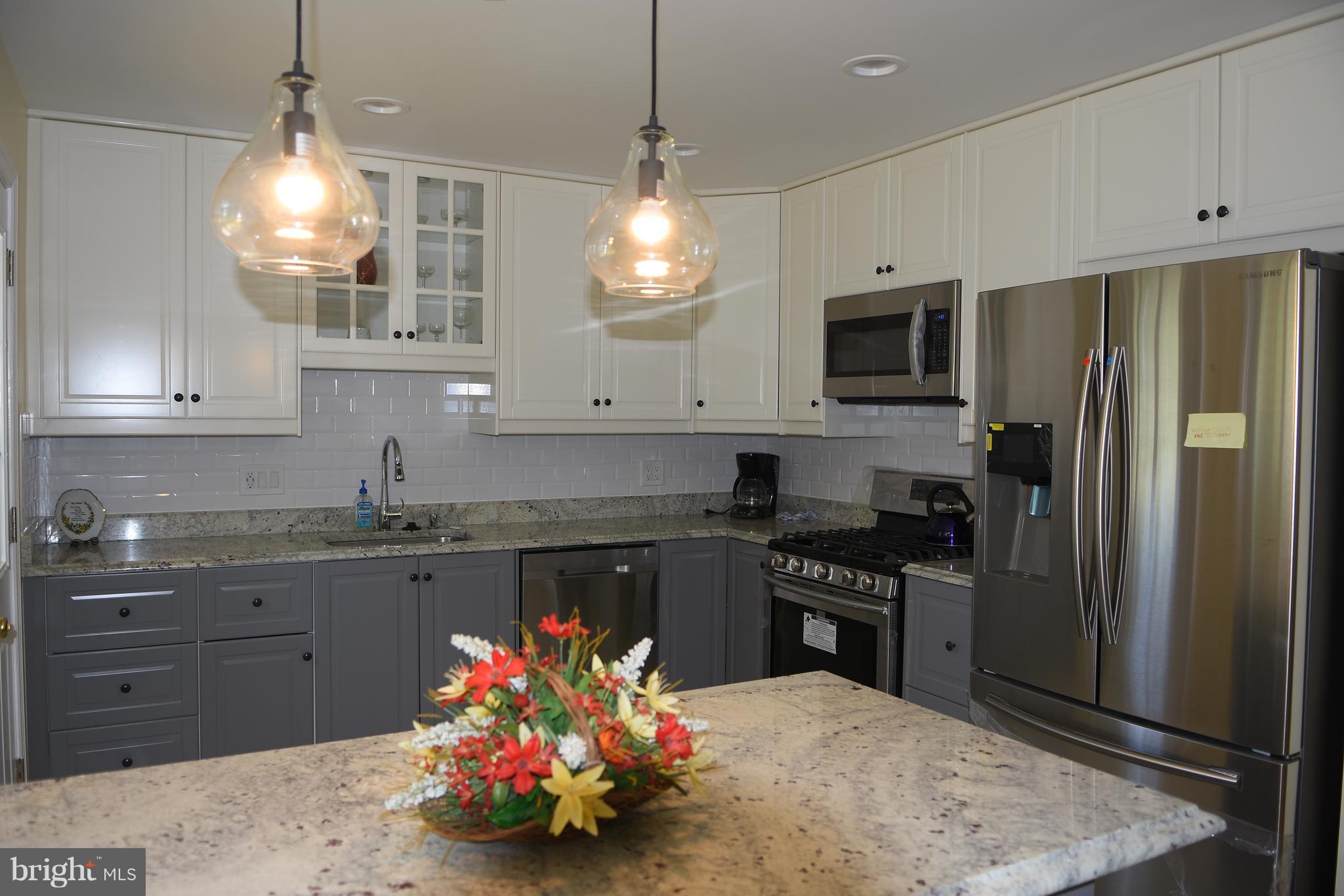 8127 Carrick Lane Springfield, VA 22151 - Photo 6 of 15 a kitchen with granite countertop a stove a refrigerator and cabinets