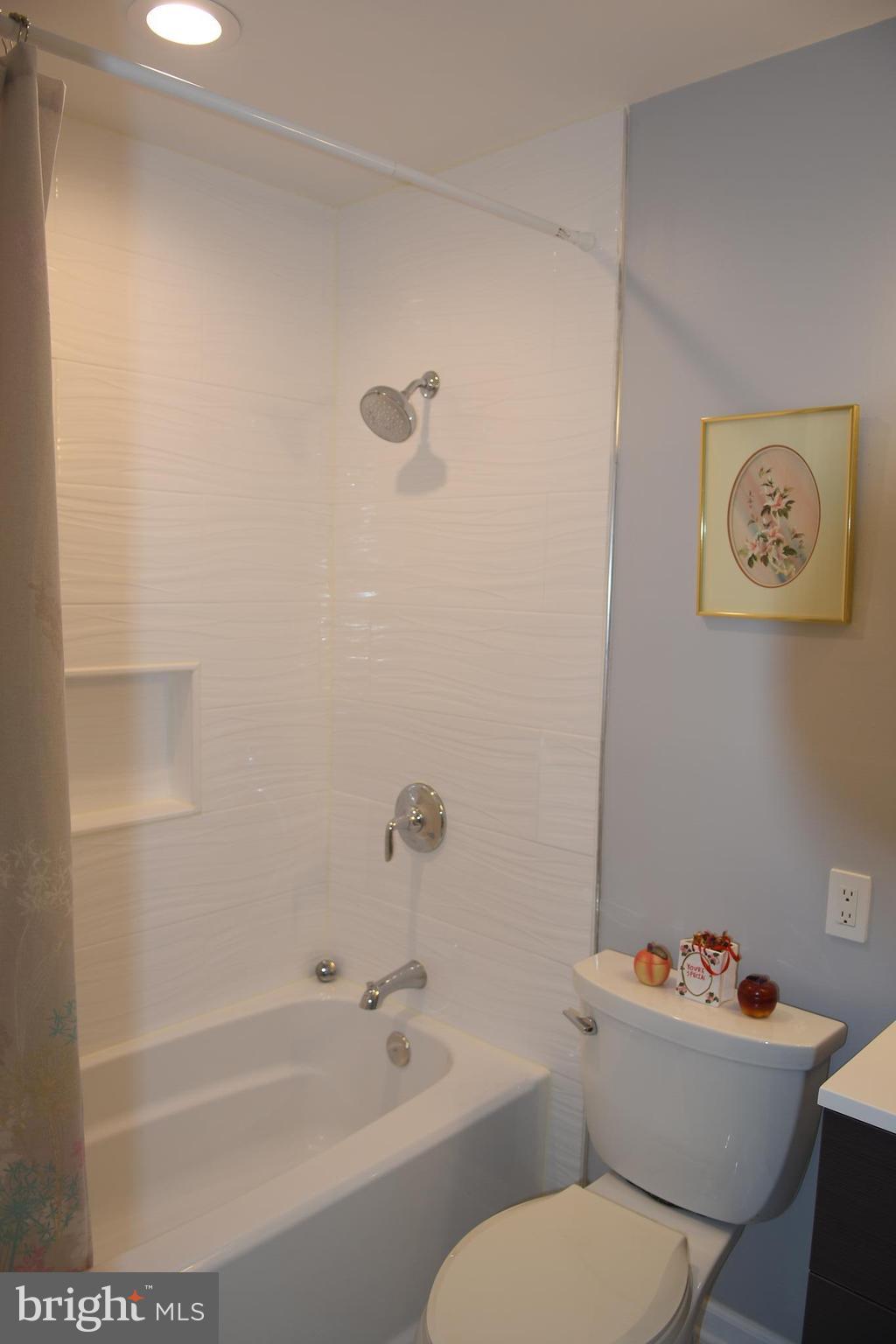 8127 Carrick Lane Springfield, VA 22151 - Photo 9 of 15 a white toilet sitting next to a bath tub