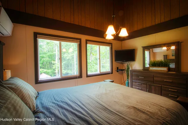 a bedroom with a bed and a large window with outer view