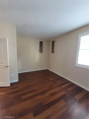 a room with wooden floor and windows