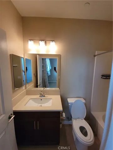 a bathroom with a sink mirror vanity and toilet