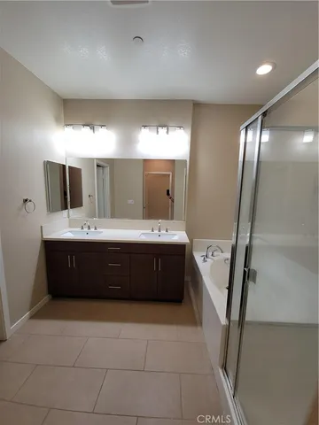a spacious bathroom with a tub sink vanity and mirror