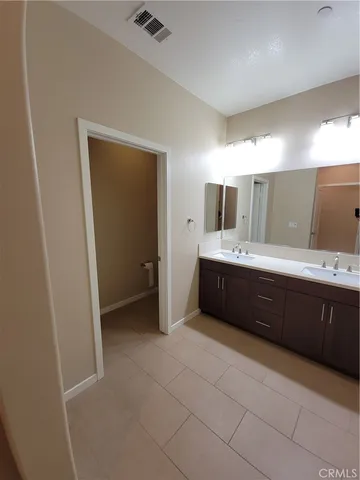 a spacious bathroom with a double vanity sink and mirror
