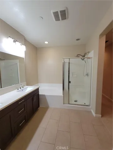 a spacious bathroom with a mirror a shower and vanity