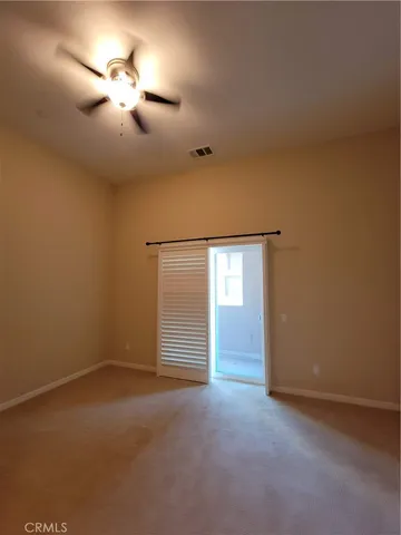 a view of an empty room with a chandelier fan