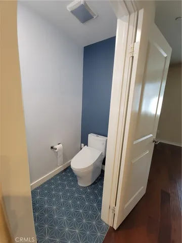 a bathroom with a granite countertop toilet and a sink