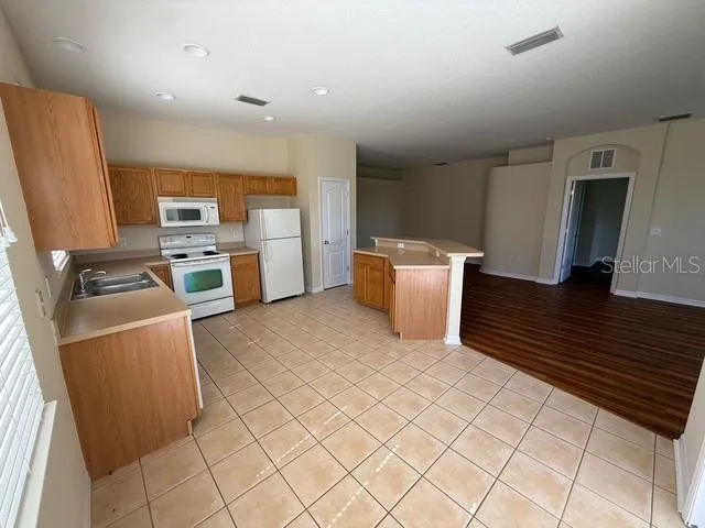 a kitchen with cabinets and wooden floor