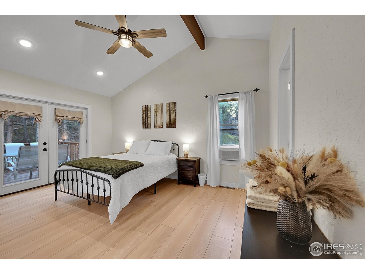 342 Brook Circle Boulder, CO 80302 - Photo 19 of 25 a spacious bedroom with a bed chandelier painting on the wall and a potted plant
