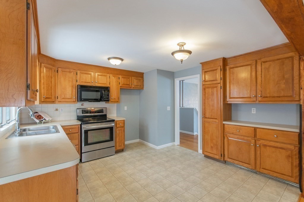214 Captain Road Longmeadow, MA 01106 - Photo 13 of 29 a kitchen with stainless steel appliances a stove top oven a sink a refrigerator and cabinets
