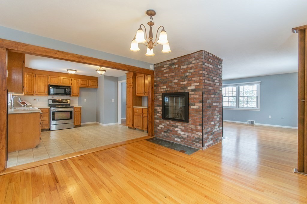 214 Captain Road Longmeadow, MA 01106 - Photo 9 of 29 a view of a livingroom with wooden floor and kitchen view