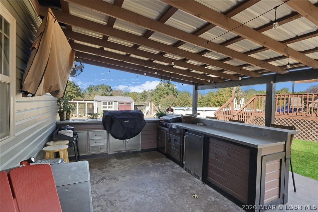 118 Uncle Dee Road Brumley, MO 65017 - Photo 37 of 57 Covered patio and outdoor kitchen with grill and f