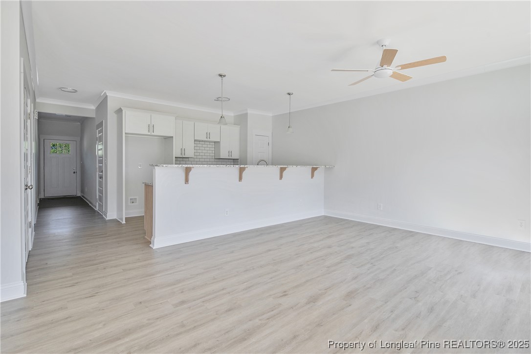 4905 High Branch Court Stedman, NC 28391 - Photo 16 of 47 a view of a kitchen with wooden floors and a ceiling fan