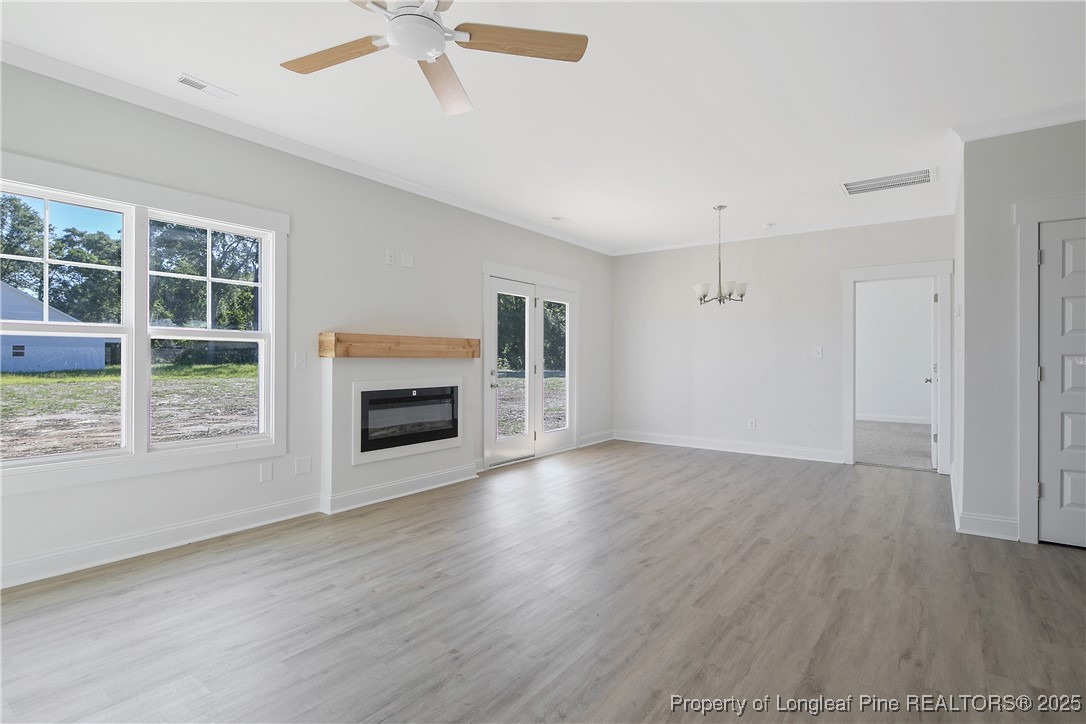 4905 High Branch Court Stedman, NC 28391 - Photo 19 of 47 wooden floor fireplace and windows in an empty room