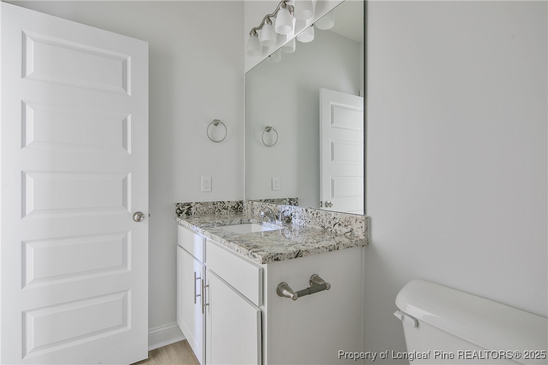 4905 High Branch Court Stedman, NC 28391 - Photo 36 of 47 a bathroom with a granite countertop sink toilet and mirror