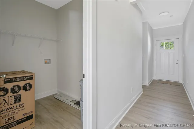 an empty room with wooden floor fireplace and windows