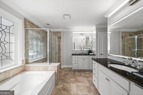 a large bathroom with a granite countertop tub sink shower and mirror