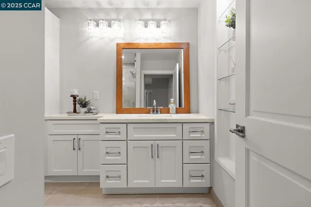a bathroom with a sink vanity and mirror