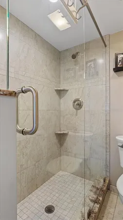 a bathroom with a granite countertop toilet sink and mirror