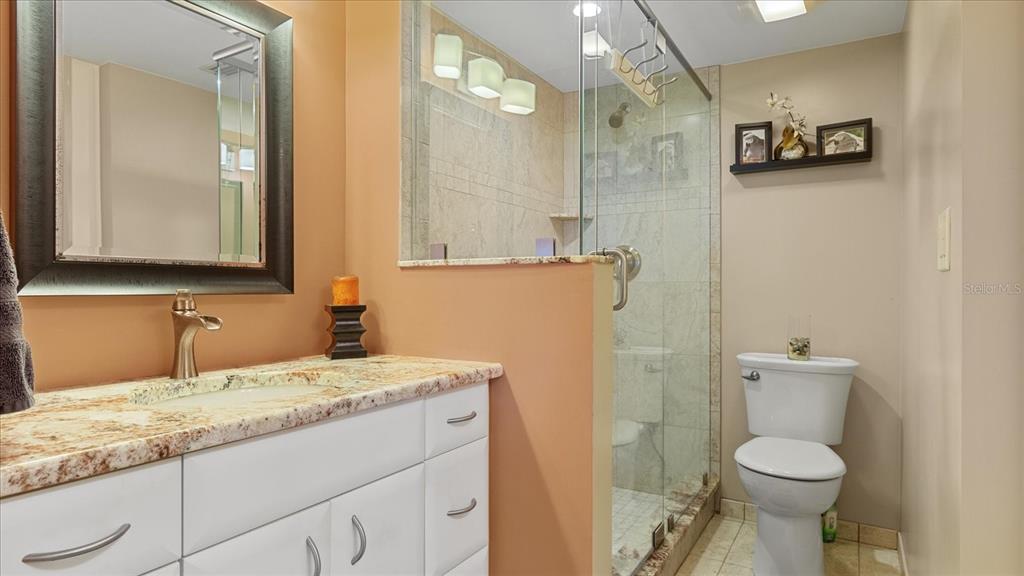 1701 Beach Road, Unit 312 Englewood, FL 34223 - Photo 29 of 39 a bathroom with a granite countertop toilet sink and mirror