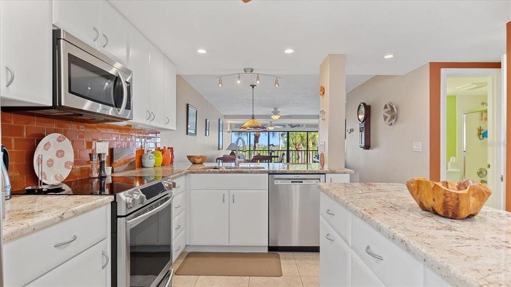 1701 Beach Road, Unit 312 Englewood, FL 34223 - Photo 6 of 39 a kitchen with stainless steel appliances granite countertop a stove a sink and a microwave