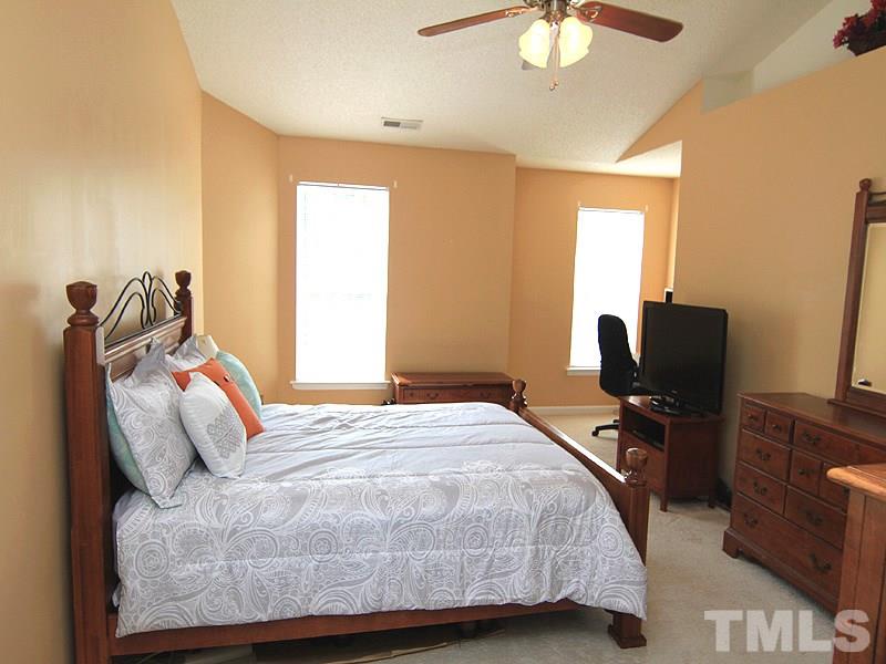 5201 Cardinal Grove Boulevard Raleigh, NC 27616 - Photo 7 of 14 a bedroom with a bed and a chandelier