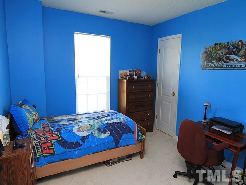 5201 Cardinal Grove Boulevard Raleigh, NC 27616 - Photo 9 of 14 a bedroom with a bed and a chair