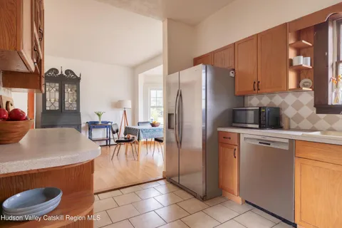 a kitchen with stainless steel appliances granite countertop a refrigerator a stove a sink and white cabinets