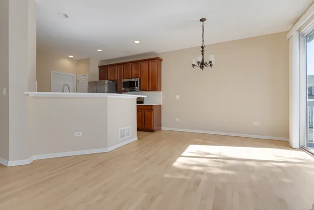 a kitchen with a refrigerator a stove top oven a sink and dishwasher with wooden floor