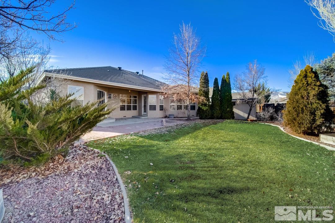 1565 Diamond Country Drive Reno, NV 89521 - Photo 7 of 30 a view of a patio with table and chairs under an umbrella