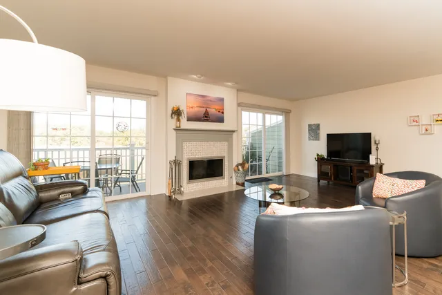 a living room with furniture a flat screen tv and a fireplace