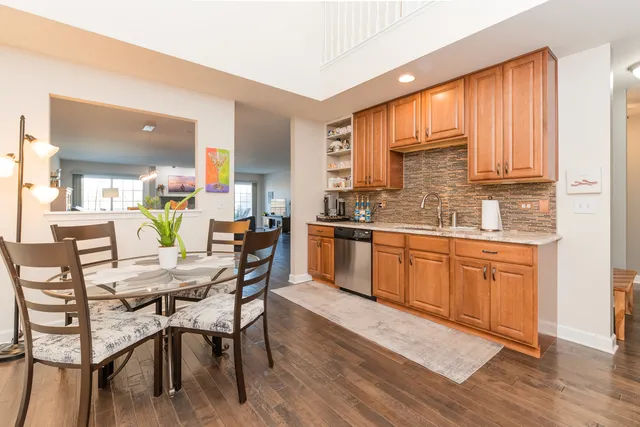 a kitchen with a table chairs sink and cabinets