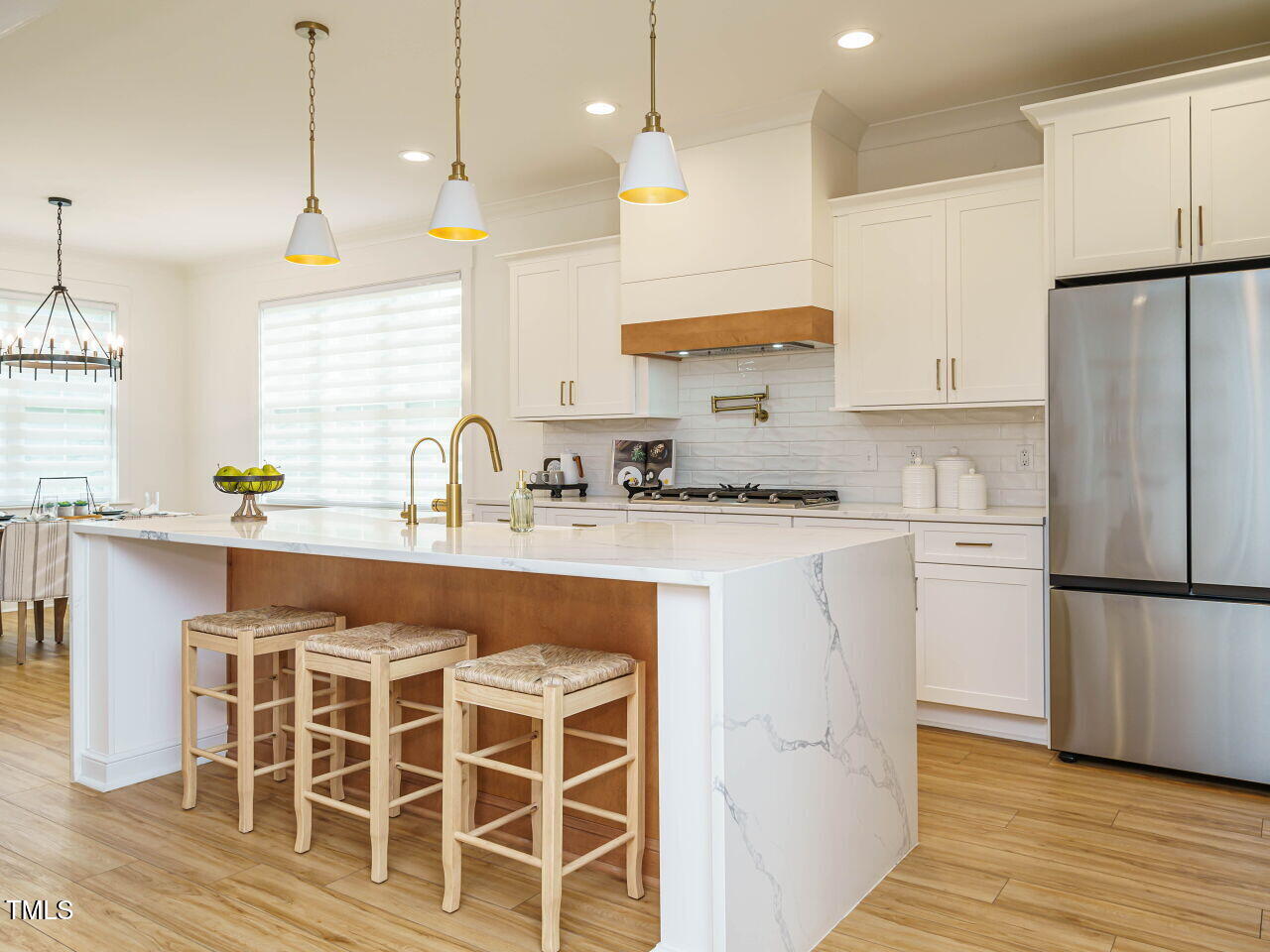 145 Putney Drive Cary, NC 27518 - Photo 16 of 38 a kitchen with kitchen island granite countertop a sink a center island stainless steel appliances and cabinets
