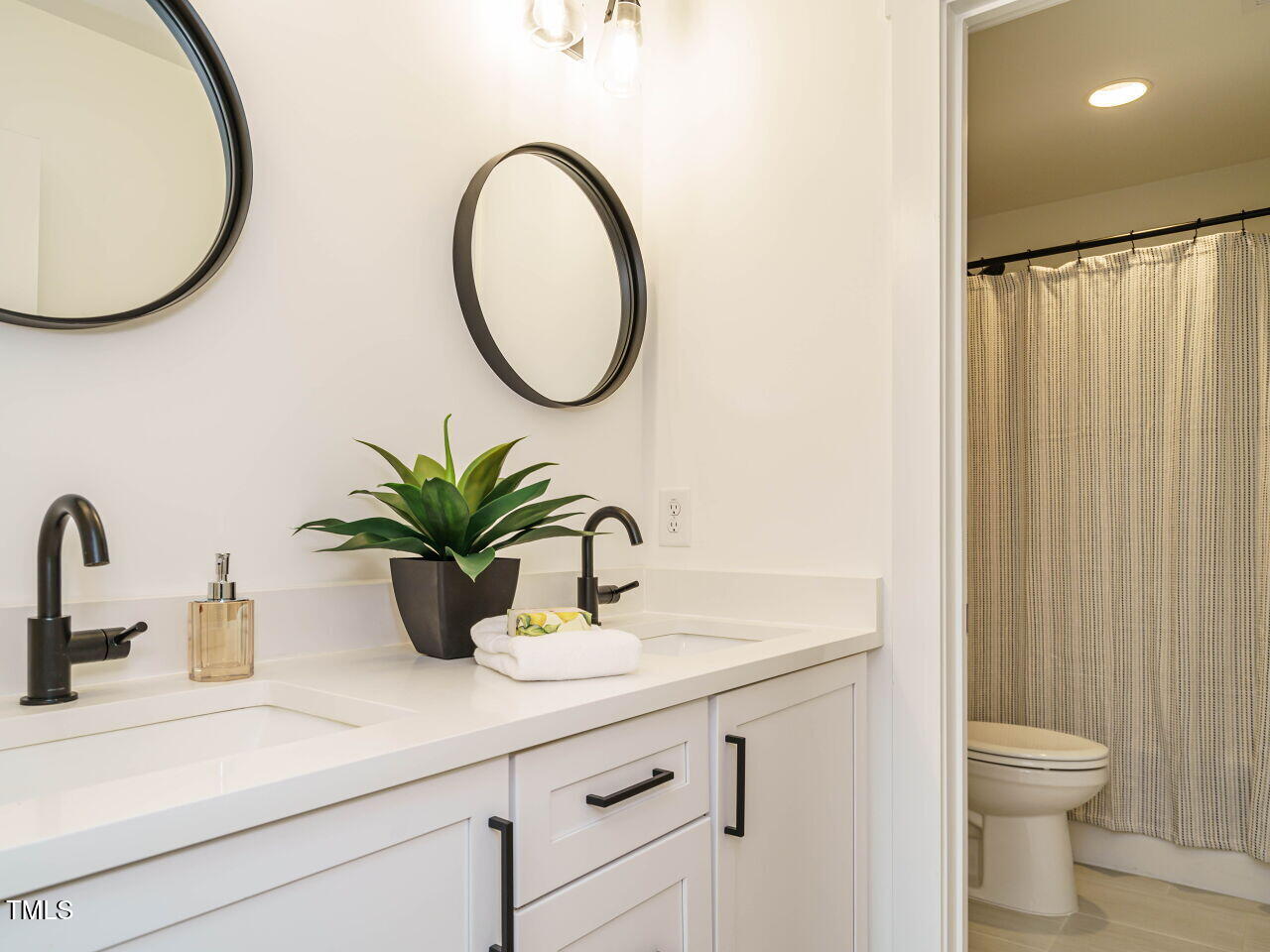 145 Putney Drive Cary, NC 27518 - Photo 33 of 38 a bathroom with a sink a mirror and a toilet