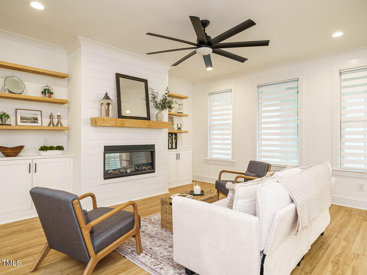 145 Putney Drive Cary, NC 27518 - Photo 9 of 38 a living room with furniture a ceiling fan and a fireplace