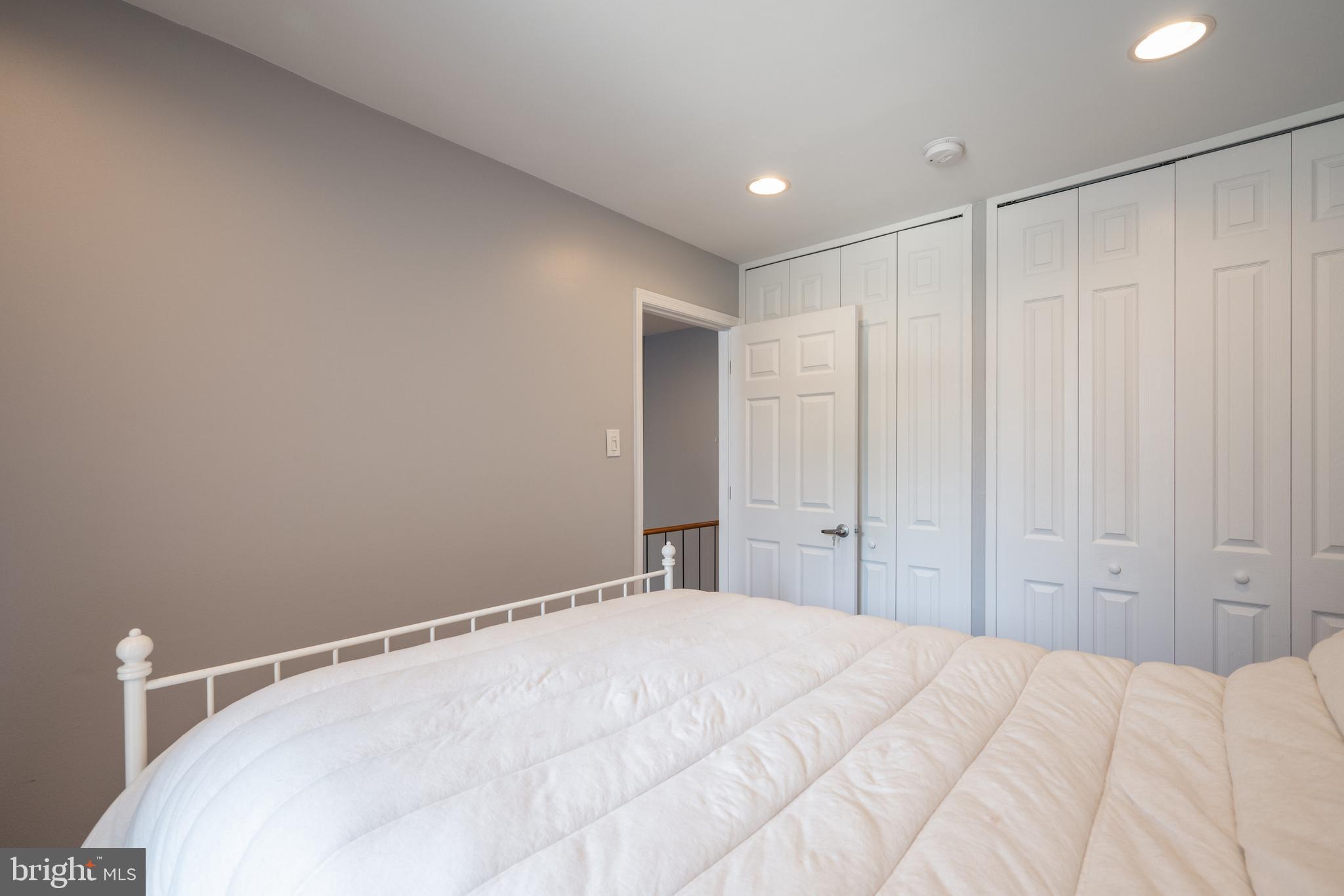 352 N Street Southwest Washington, DC 20024 - Photo 23 of 57 a large white bed in a white room with closet and chandelier