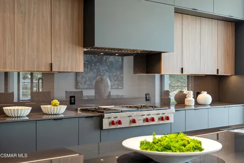 a kitchen with stainless steel appliances kitchen island granite countertop a table chairs and a refrigerator