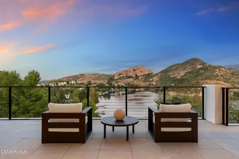 a view of a terrace with couches and wooden fence