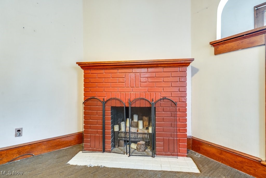 Detailed view of a brick fireplace and baseboards