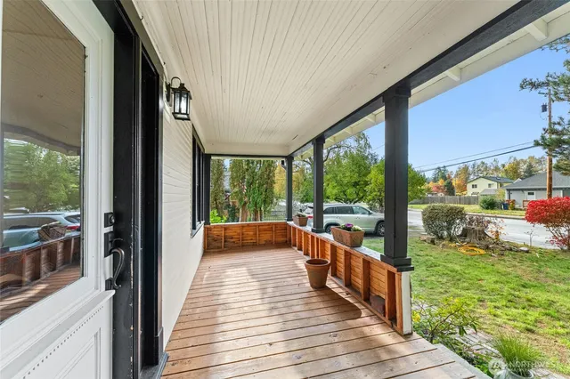 a view of a balcony with chairs and wooden floor
