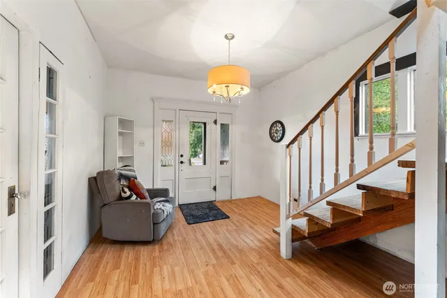 a living room with wooden floors and a chandelier