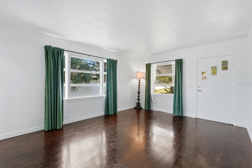 231 North Ridgewood Avenue Ormond Beach, FL 32174 - Photo 5 of 52 a view of an empty room with wooden floor and a window